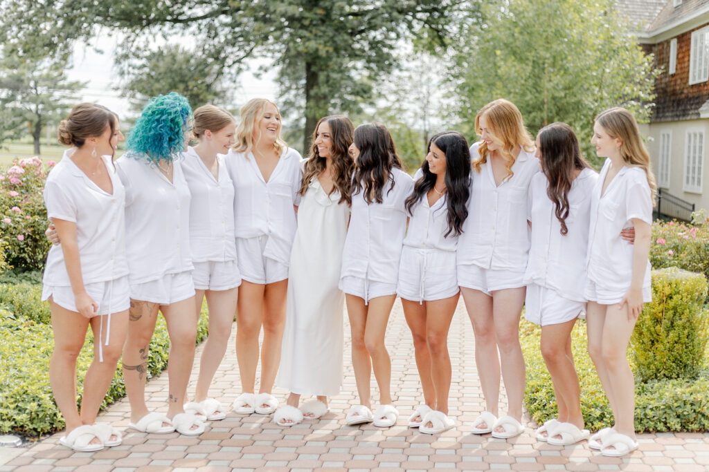 Bride and bridesmaid in matching pajamas outside of Hayloft Cottage, the Ryland Inn wedding venue