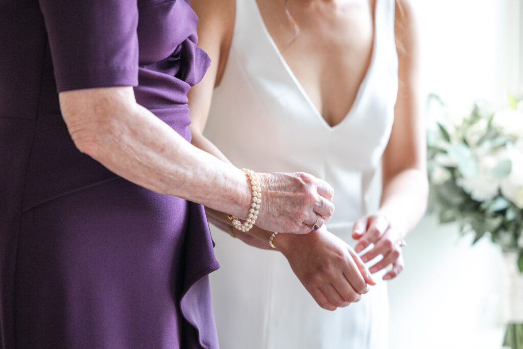 Bride getting ready details - Mom clasping bracelet