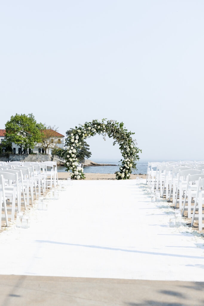 Wedding ceremony with centerpieces details and a water backdrop