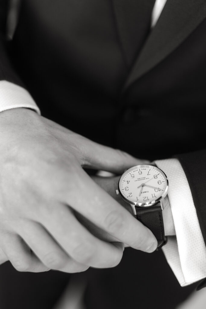 Groom getting ready close up watch shot inside clubhouse wedding venue