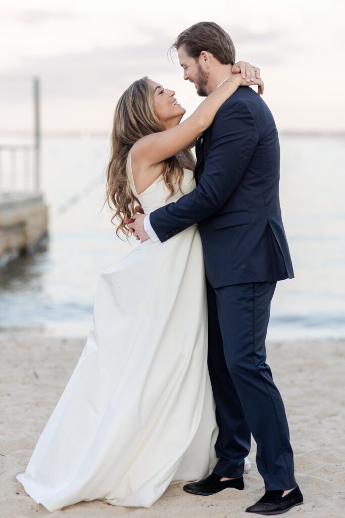 Bride and groom sunset photos on the sand with purple skies 