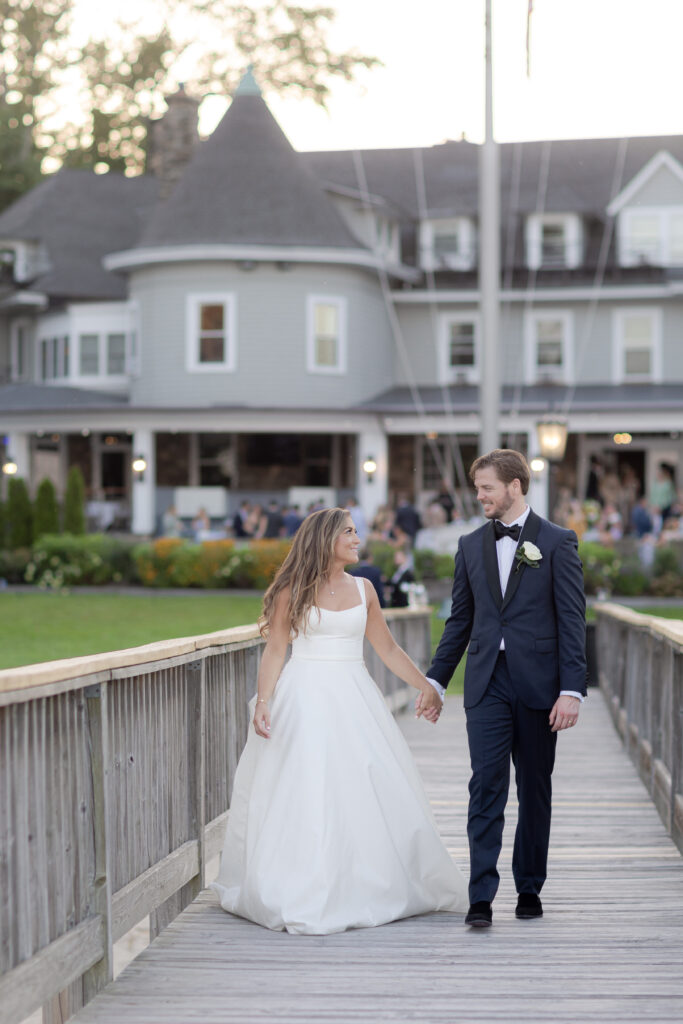 Bride and groom on bridge in front of Orienta Beach Club