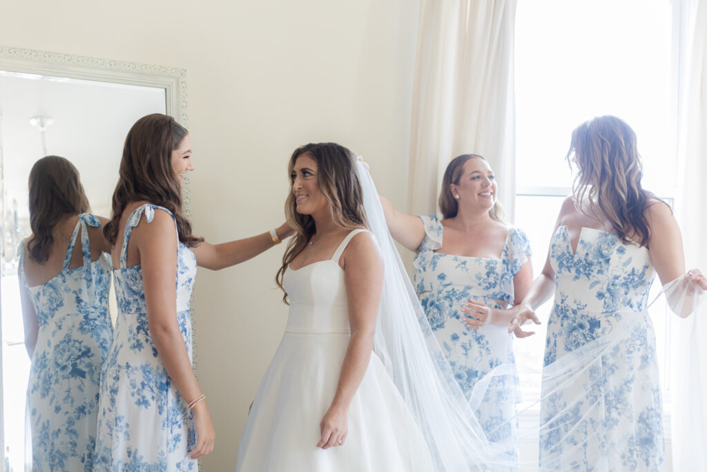 Bride getting ready in bridal suite with bridesmaid inside beach club wedding venue