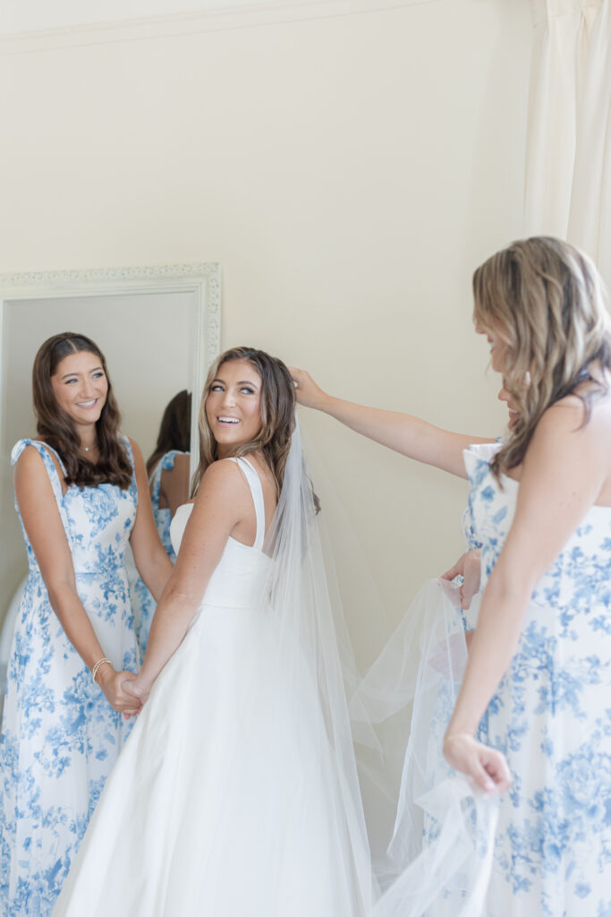 Bride getting ready in bridal suite with bridesmaid inside beach club wedding venue