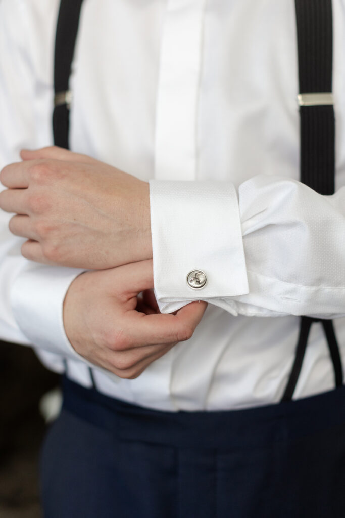 Groom getting ready with close up cufflinks 