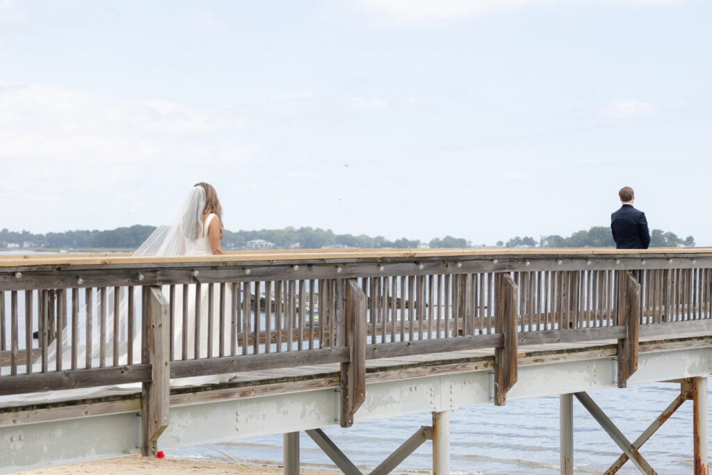 Bride and groom first look at bridge outside of clubhouse wedding venue