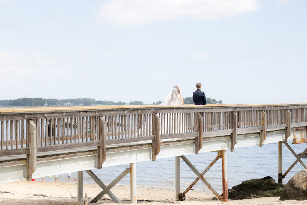 Bride and groom first look at bridge outside of clubhouse wedding venue