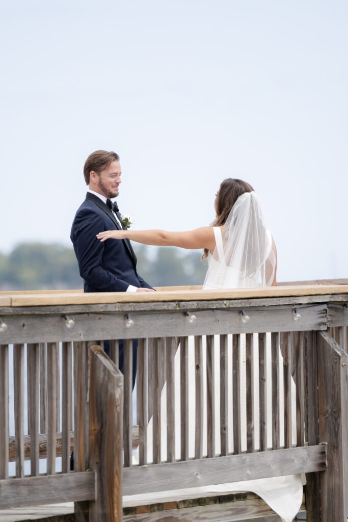 Bride and groom first look at bridge outside of clubhouse wedding venue