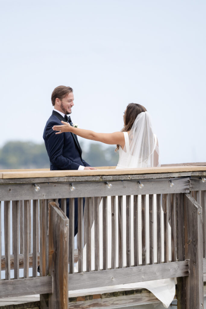 Bride and groom first look at bridge outside of clubhouse wedding venue