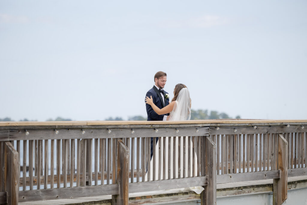 Bride and groom first look at bridge outside of clubhouse wedding venue