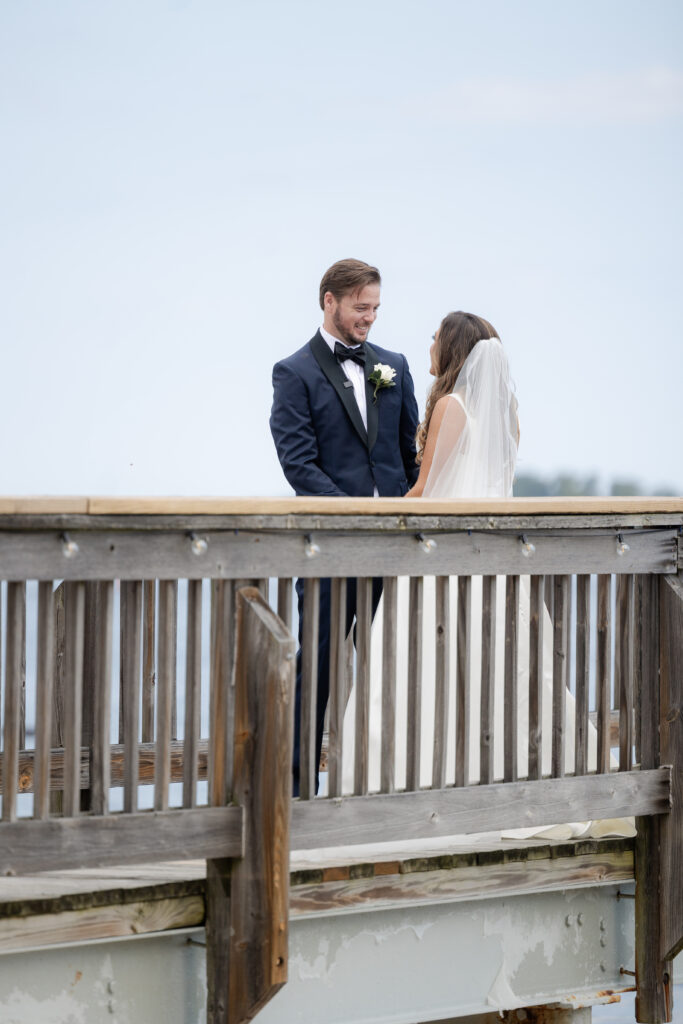 Bride and groom first look at bridge outside of clubhouse wedding venue