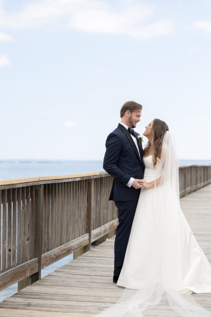 Bride and groom first look at bridge outside of clubhouse wedding venue