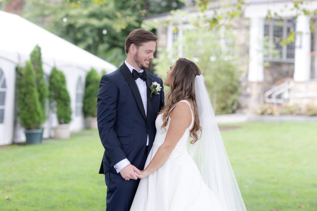 Bride and groom portraits  on the grass in front of clubhouse wedding venue