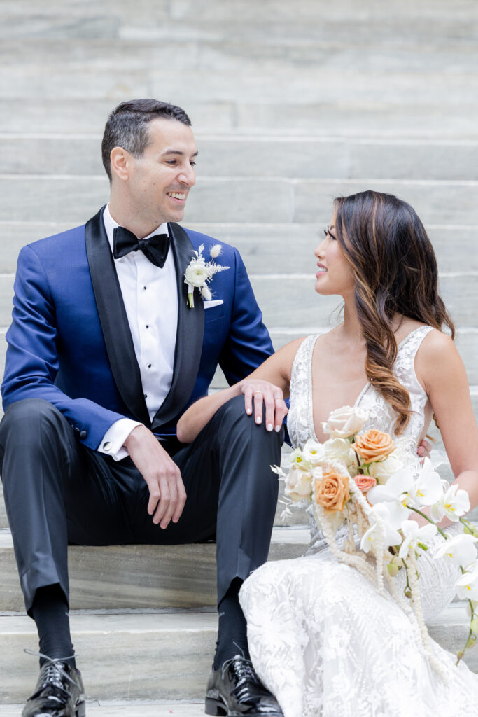 Bride and groom on the white steps outside of New York Public Library