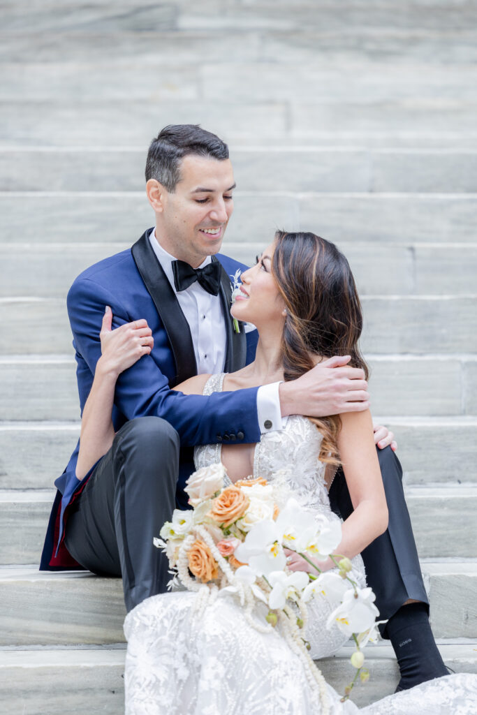 Bride and groom on the white steps outside of New York Public Library