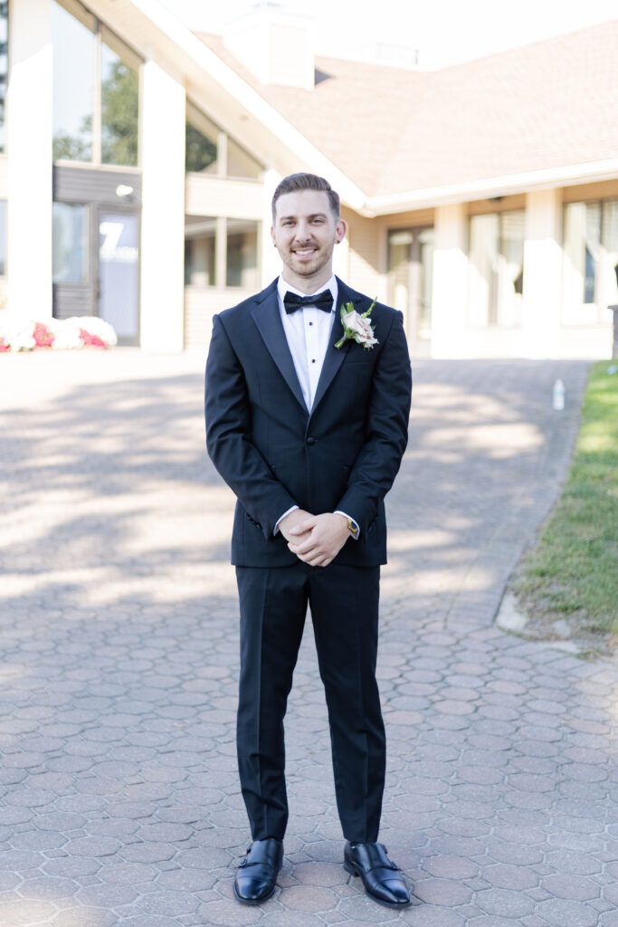 Groom portraits in front of golf course wedding venue