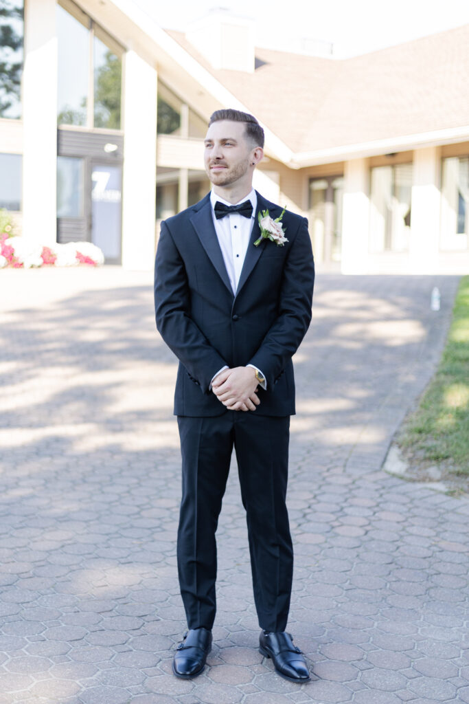 Groom portraits in front of golf course wedding venue