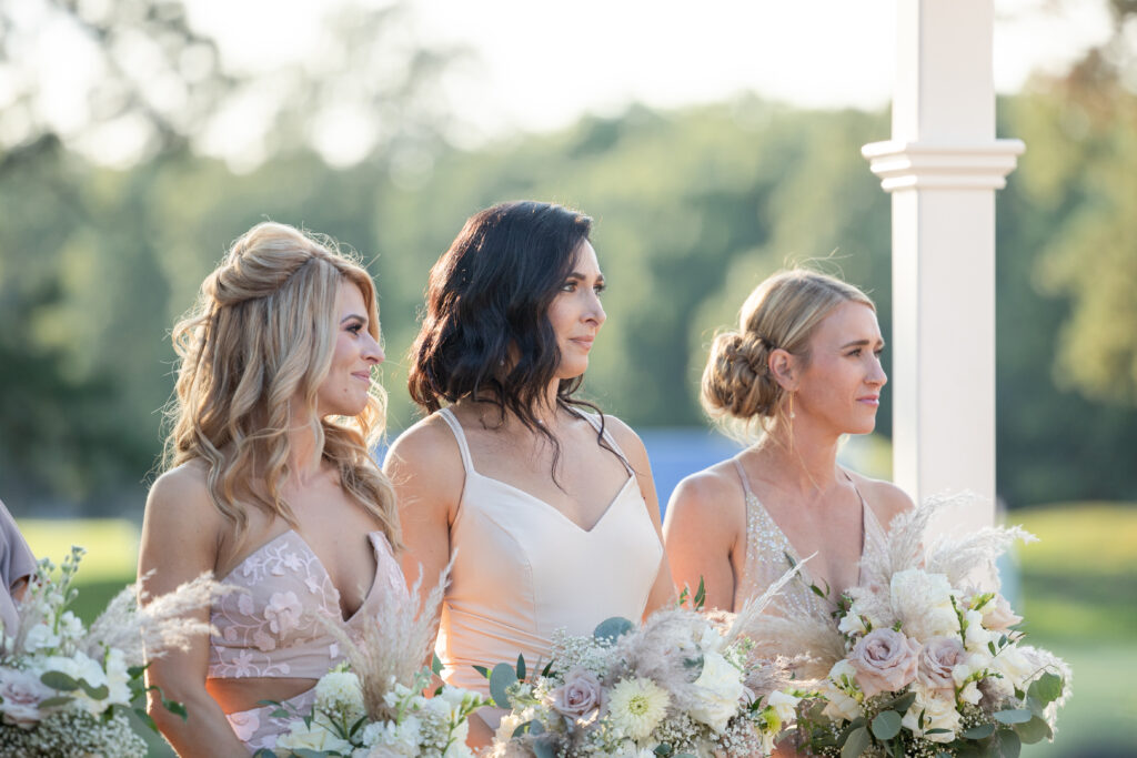 Bridesmaid reactions during outdoor wedding ceremony