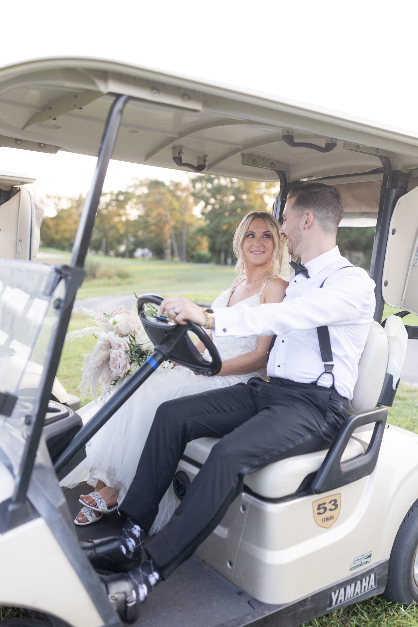 Bride and groom on golf cart at golf club wedding venue