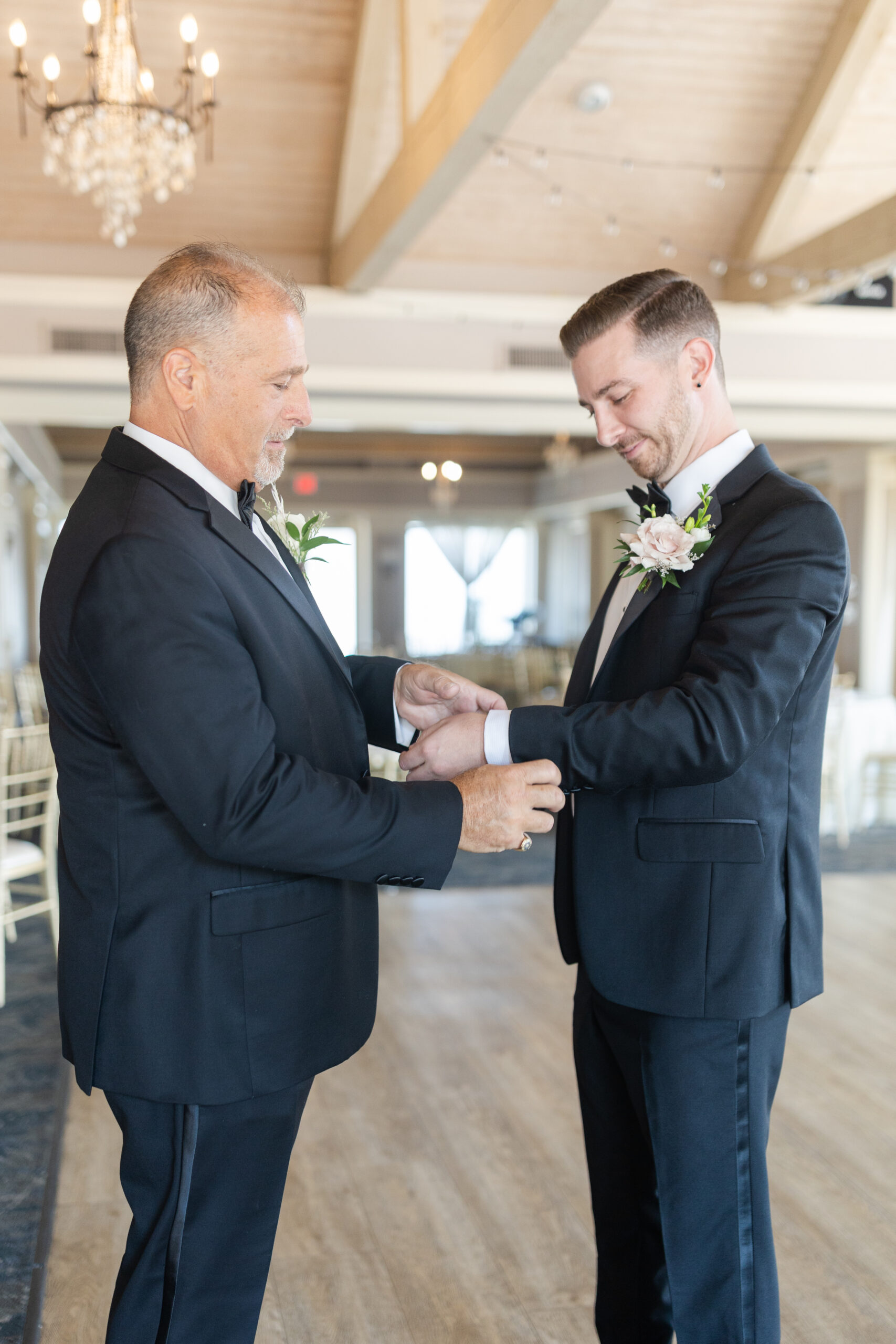 Groom getting dressed with dad at golf club wedding venue