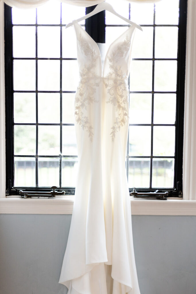 Wedding dress against window inside bridal suite