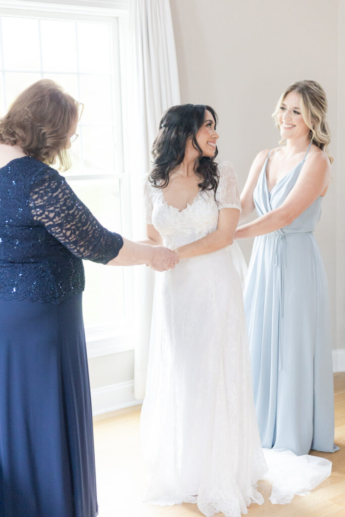 Bride getting dress on inside bridal suite