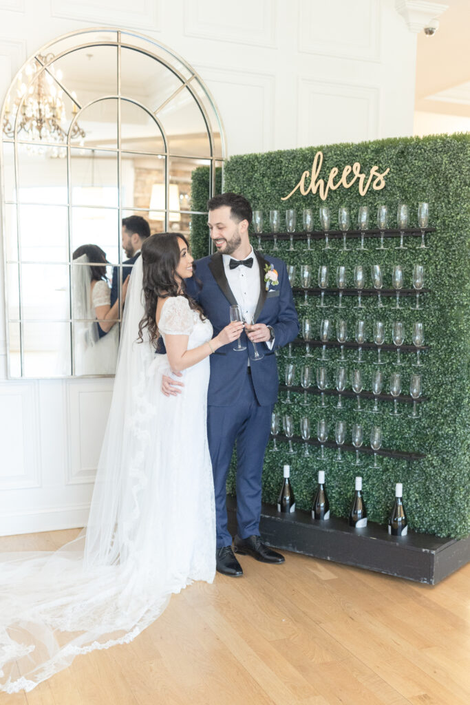 Bride and groom in front of champaign wall