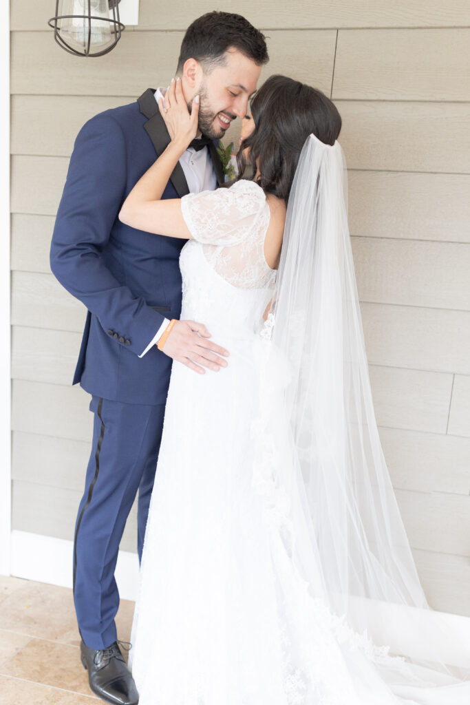 Bride and groom against wall outside