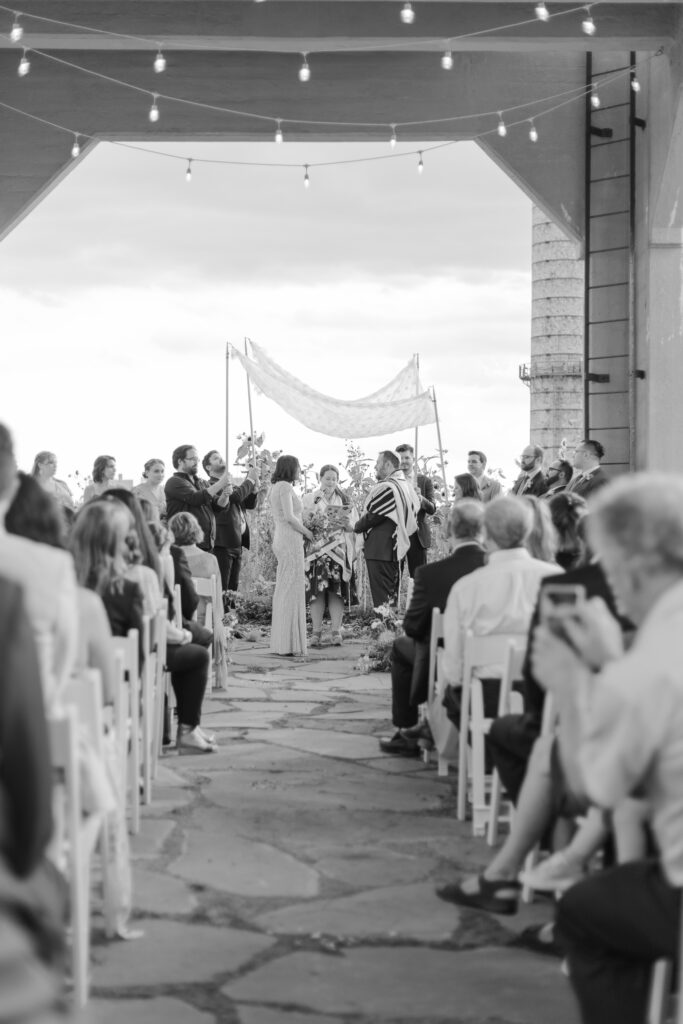 Black and white photo of jewish wedding ceremony at venue rooftop