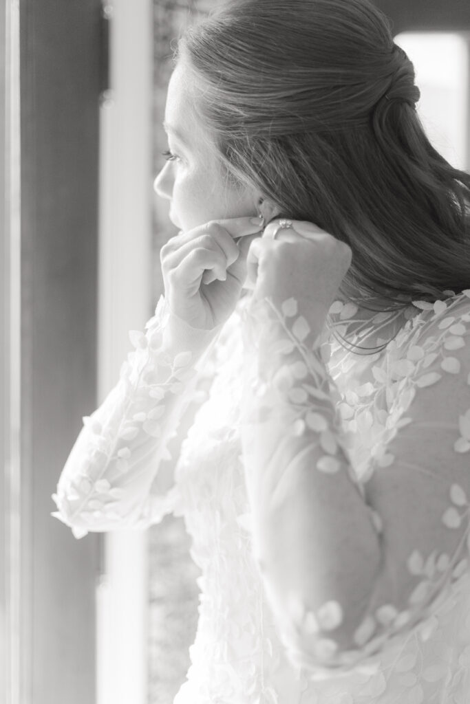 Bride putting on earrings