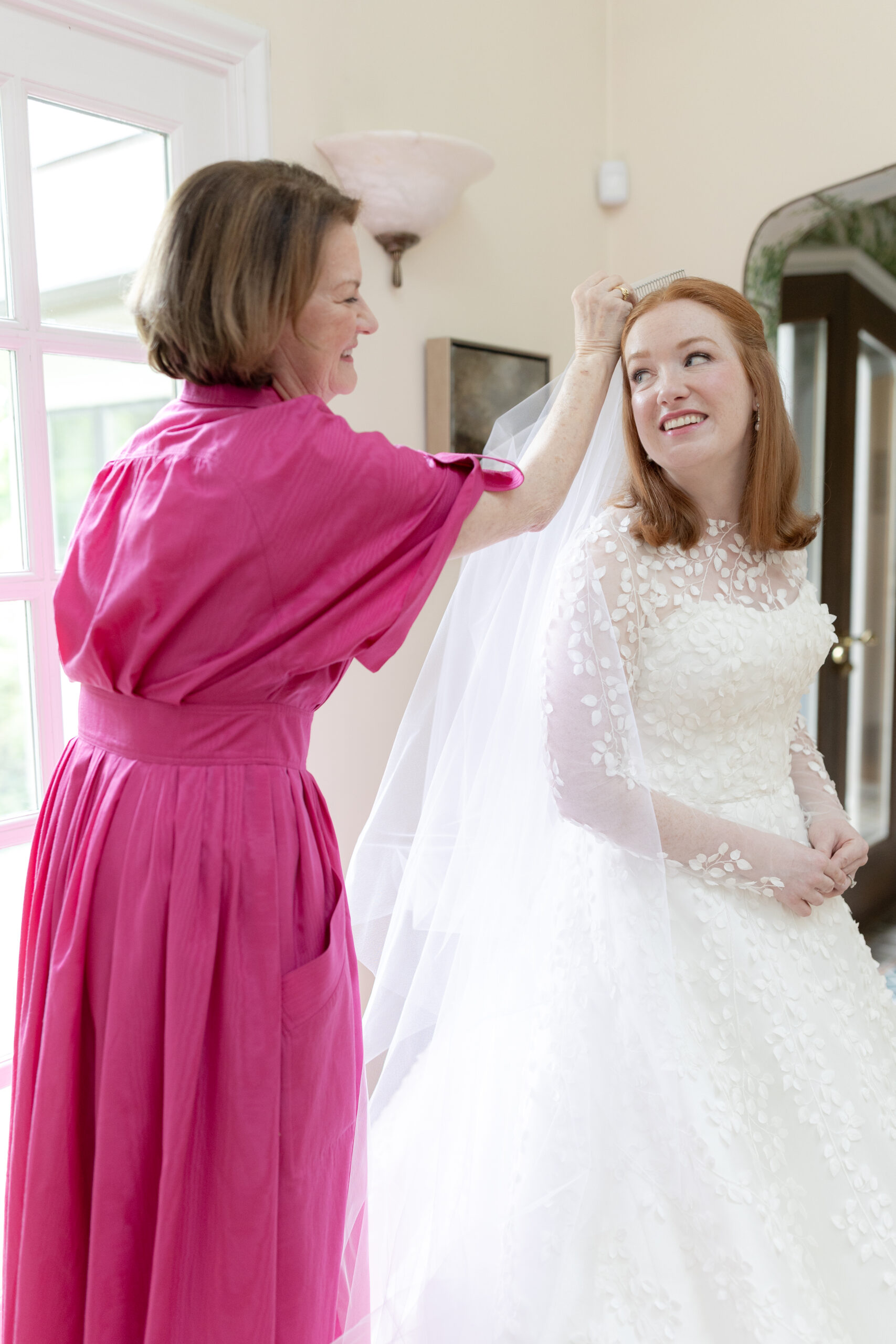 Bride and mom putting on veil