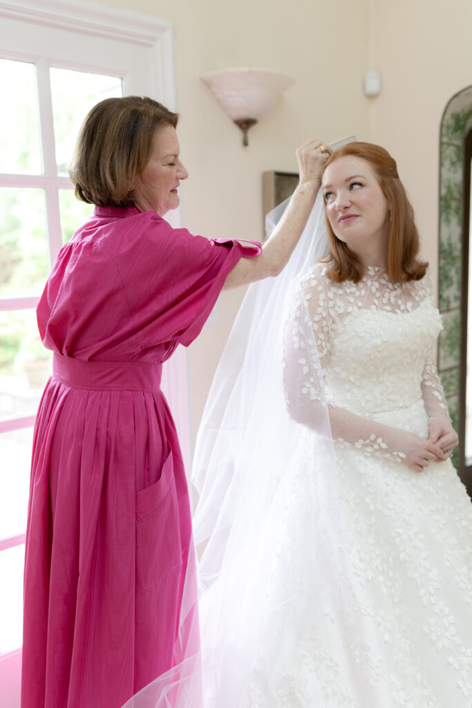 Bride and mom putting on veil