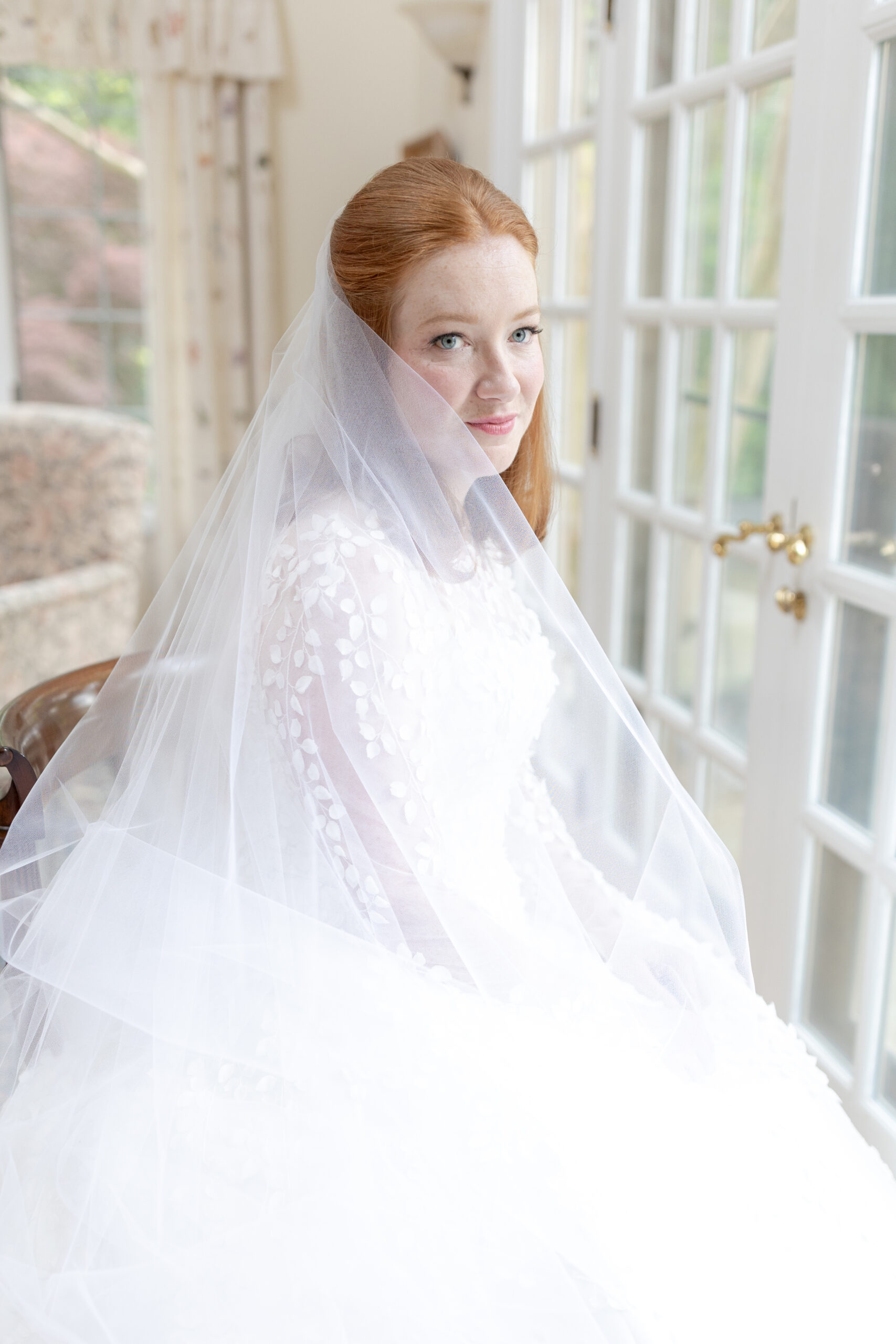 Bride with veil in front of window