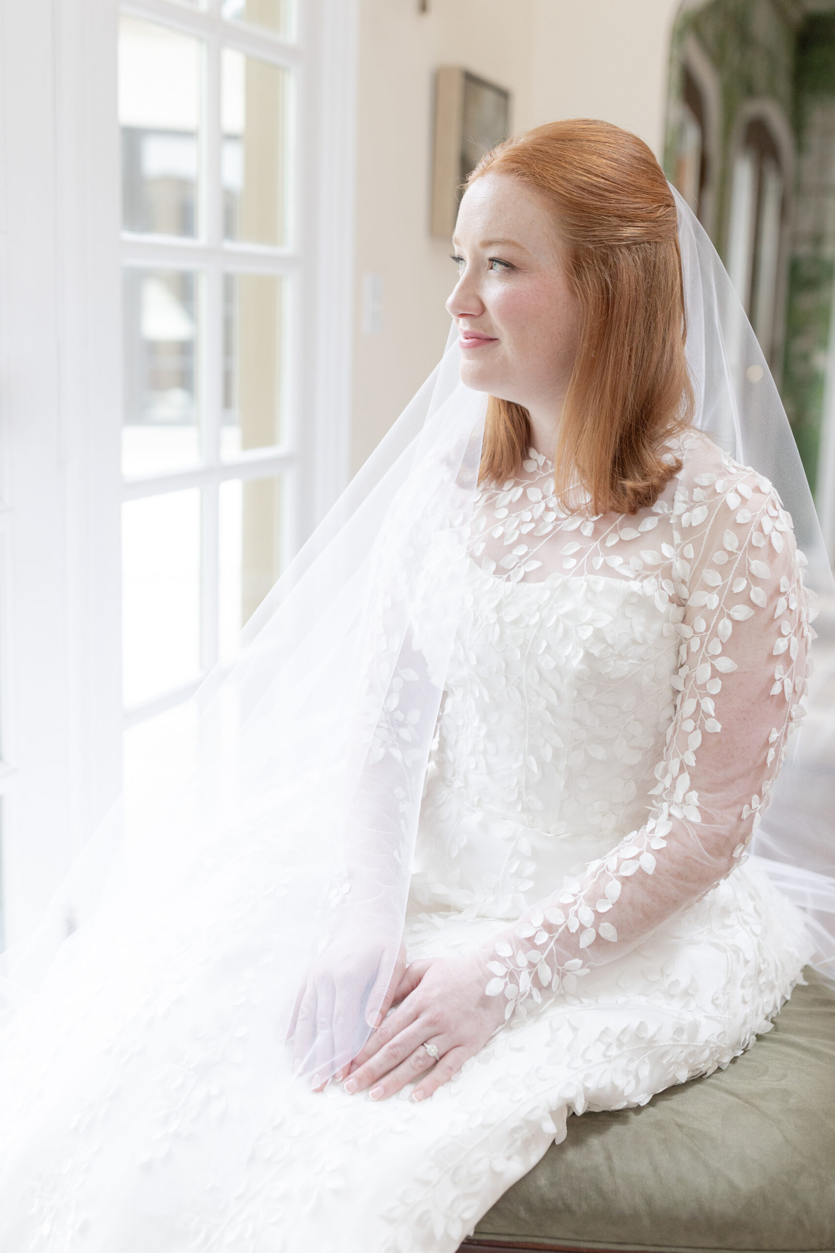 Bride with veil in front of window