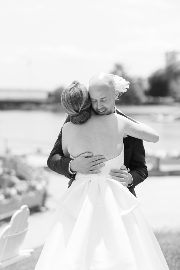 Black and white of bride and groom first look in front of waterfront view