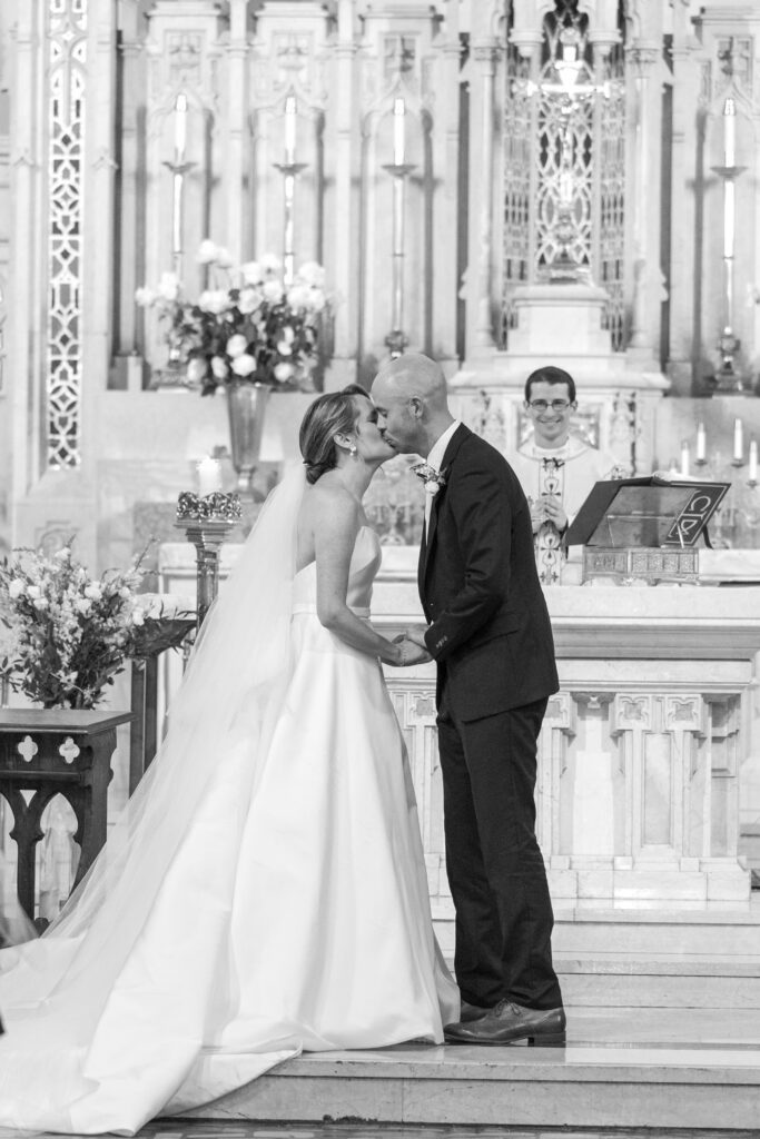 Bride and groom first kiss at church aisle