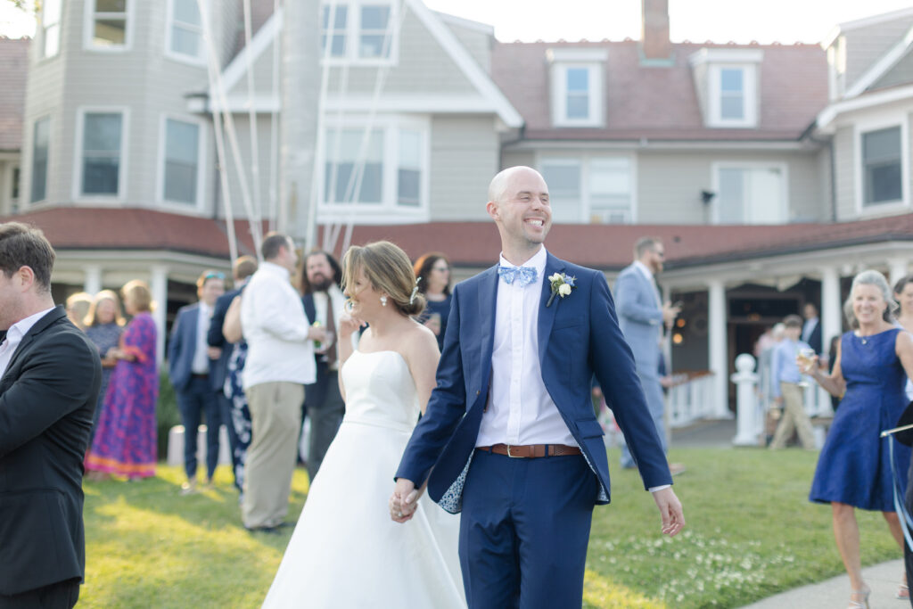 Bride and groom walking outside of yacht club wedding venue