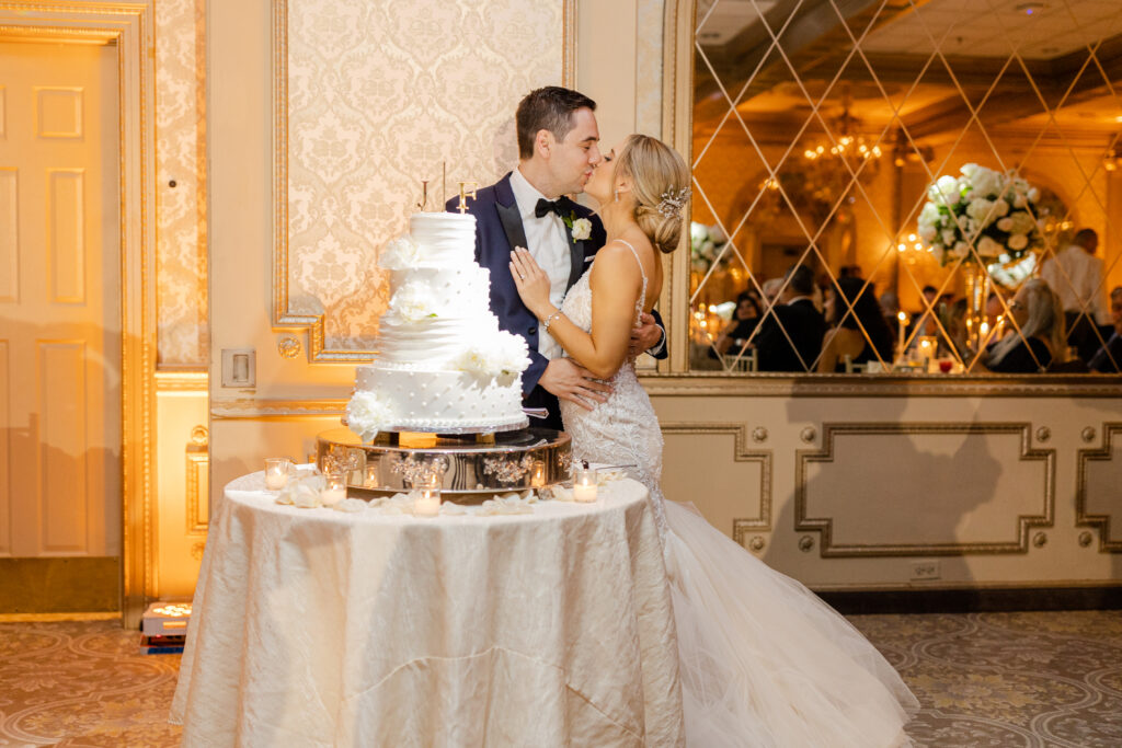 Cake cutting with bride and groom inside wedding reception