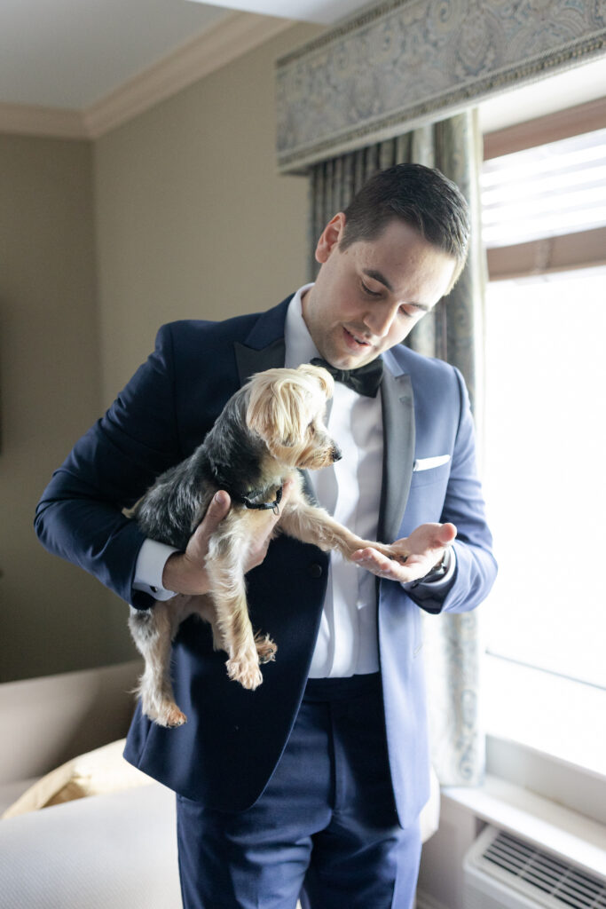 Groom with dog inside groom's suite at Madison Hotel Wedding Venue