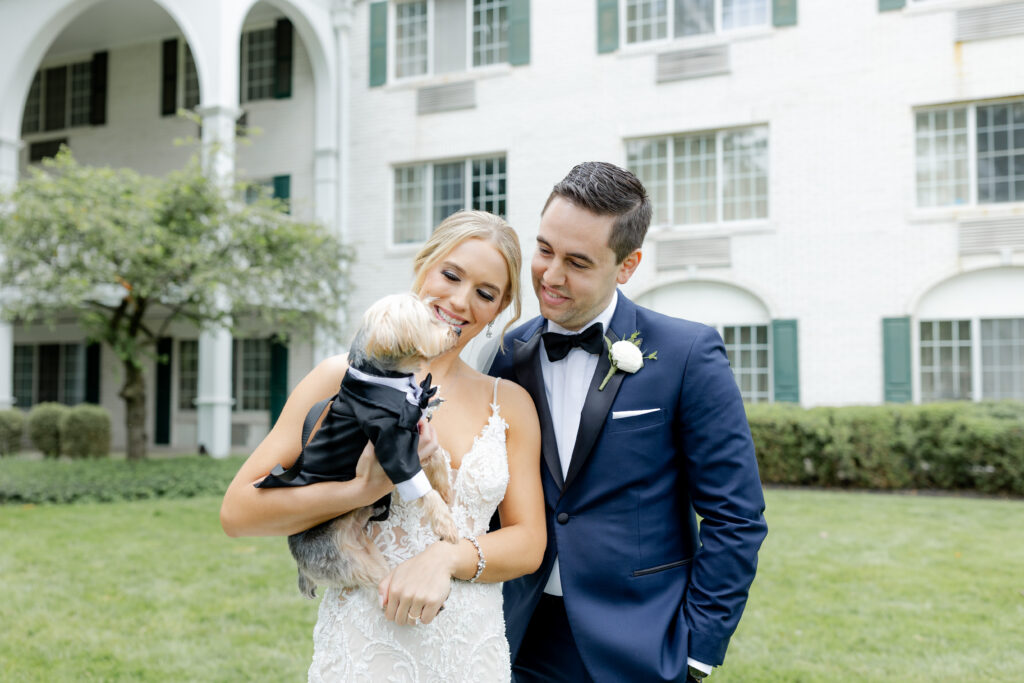 Bride, groom, and their dog outside of New Jersey wedding venue