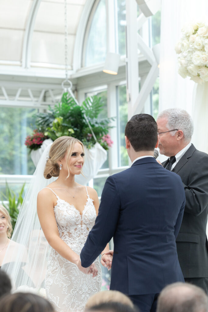 Bride and groom at wedding ceremony inside Madison Hotel Conservatory