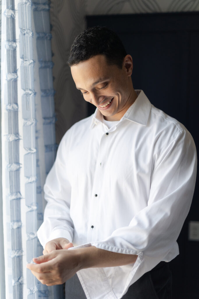 Groom putting on cufflinks at Salem Hotel Waterfront