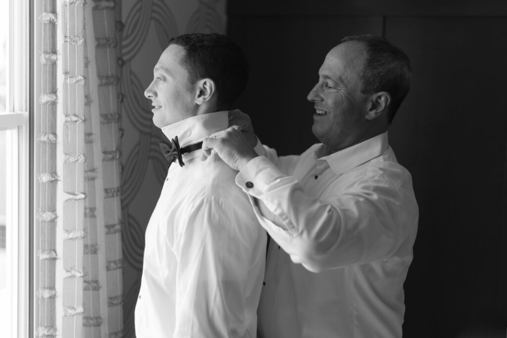 Groom's dad putting on bow-tie at Salem Hotel Waterfront