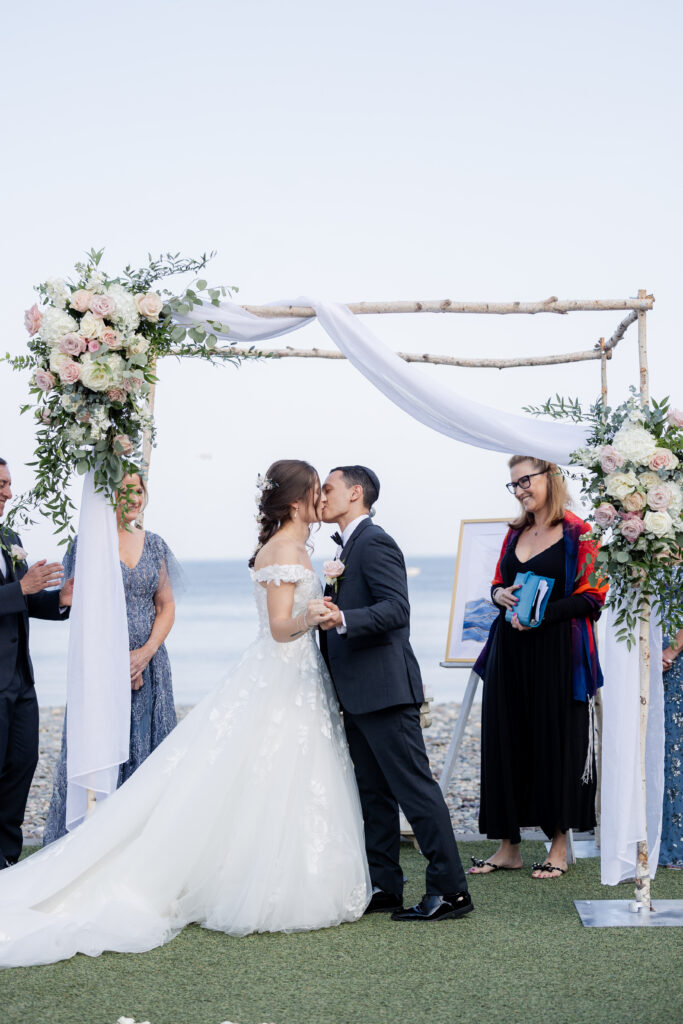 First kiss at outdoor wedding ceremony in Massachusetts