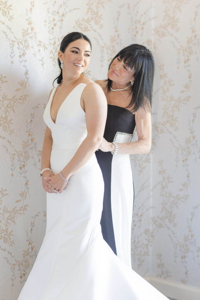 Bride and mom getting dressed in bridal suite