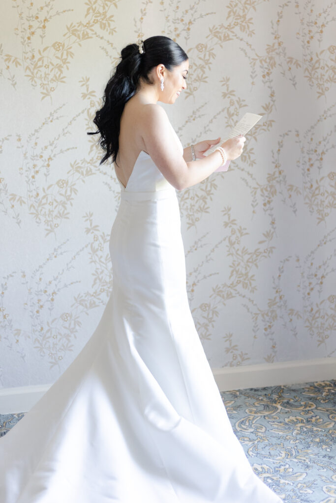 Bride reading groom letter in country golf club bridal suite