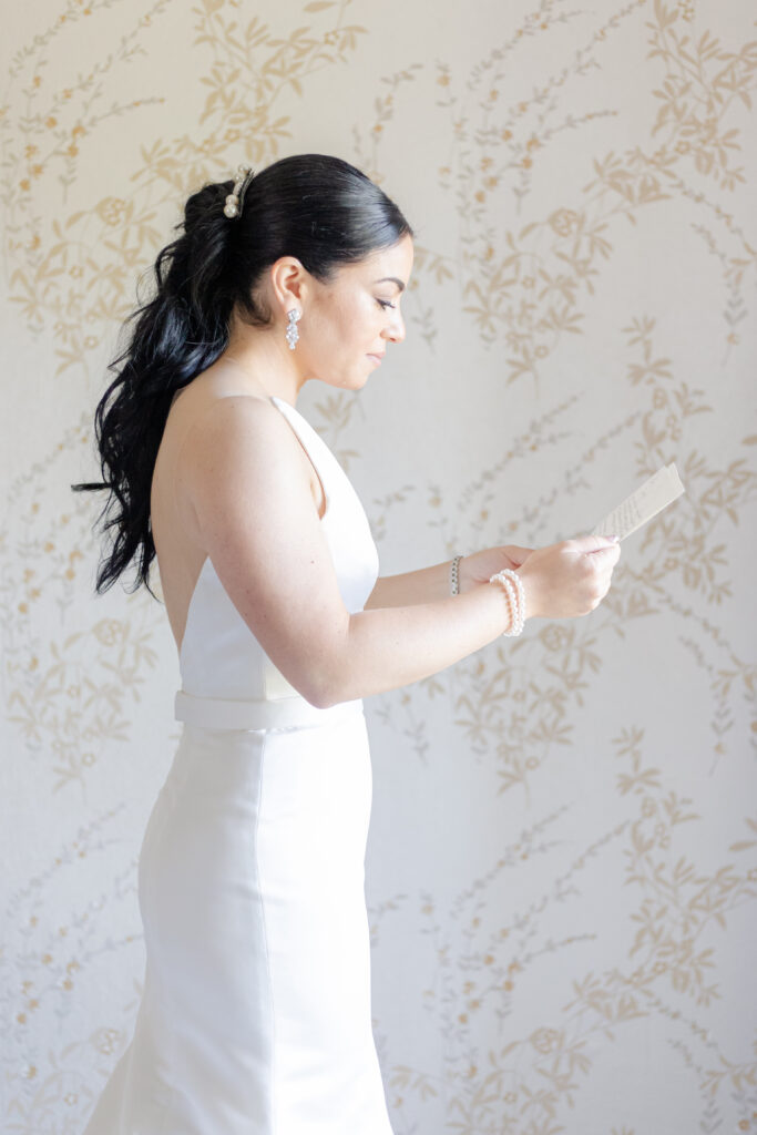 Bride reading groom letter in country golf club bridal suite