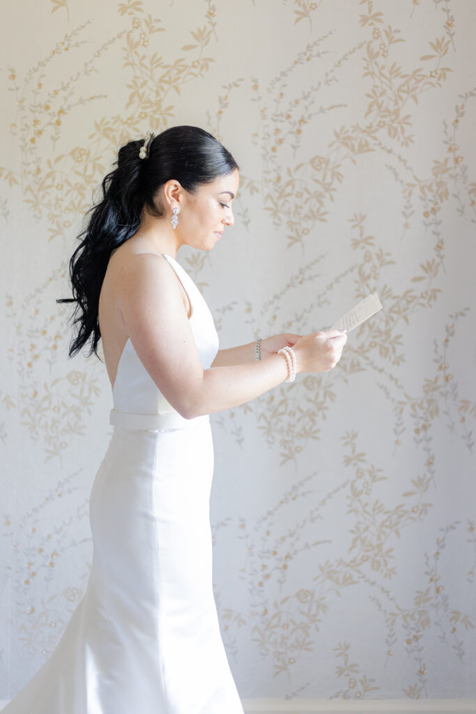 Bride reading groom letter in country golf club bridal suite