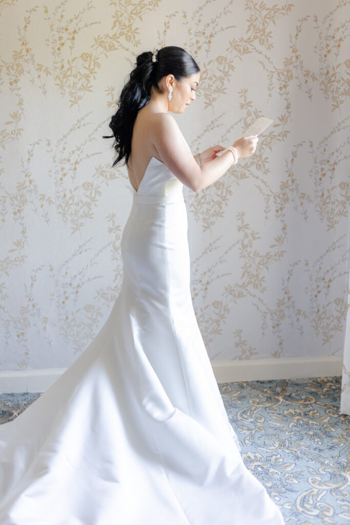 Bride reading groom letter in country golf club bridal suite