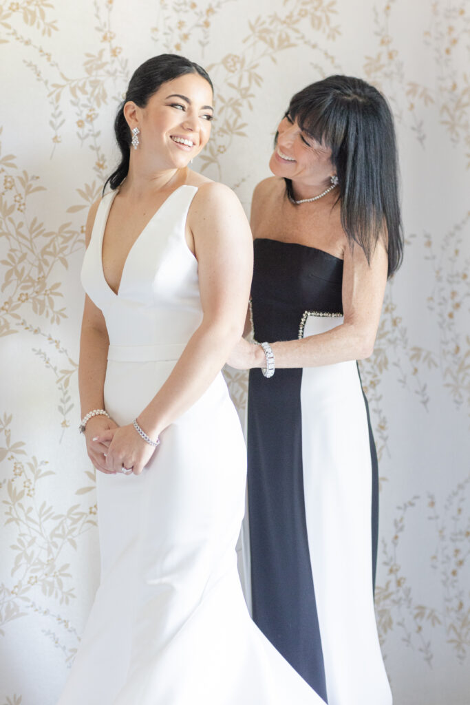 Bride and mom getting dressed in bridal suite